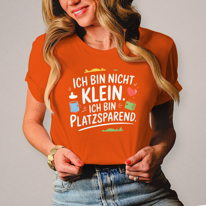 Damen T-Shirt „Ich bin nicht klein – ich bin platzsparend“ – Lustiges Spruchshirt (weisse Schrift)